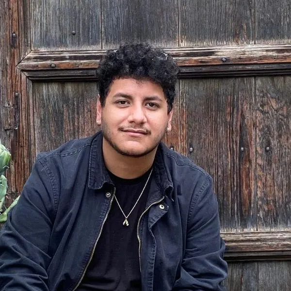 Team member Eddy smiling in front of a wooden door