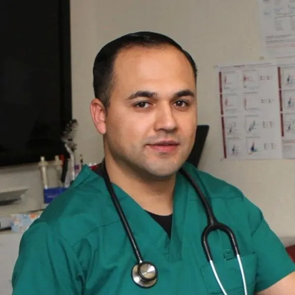 Team member Edwin in green scrubs with a stethoscope