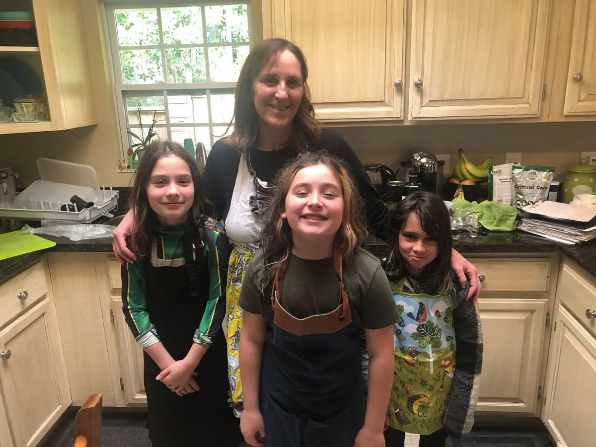 A family in aprons smiling together in their kitchen