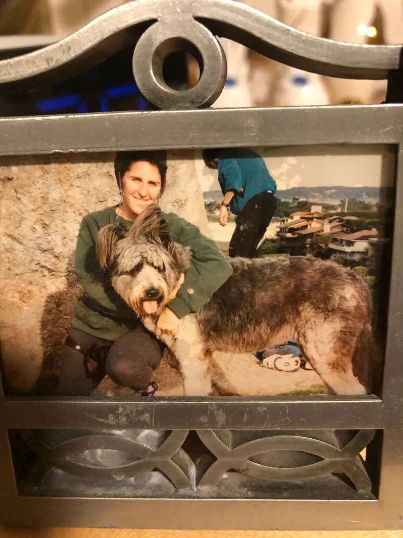 A framed photo of a woman with a large shaggy dog