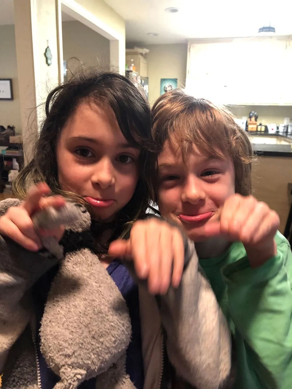 Two children smiling with a pet rat