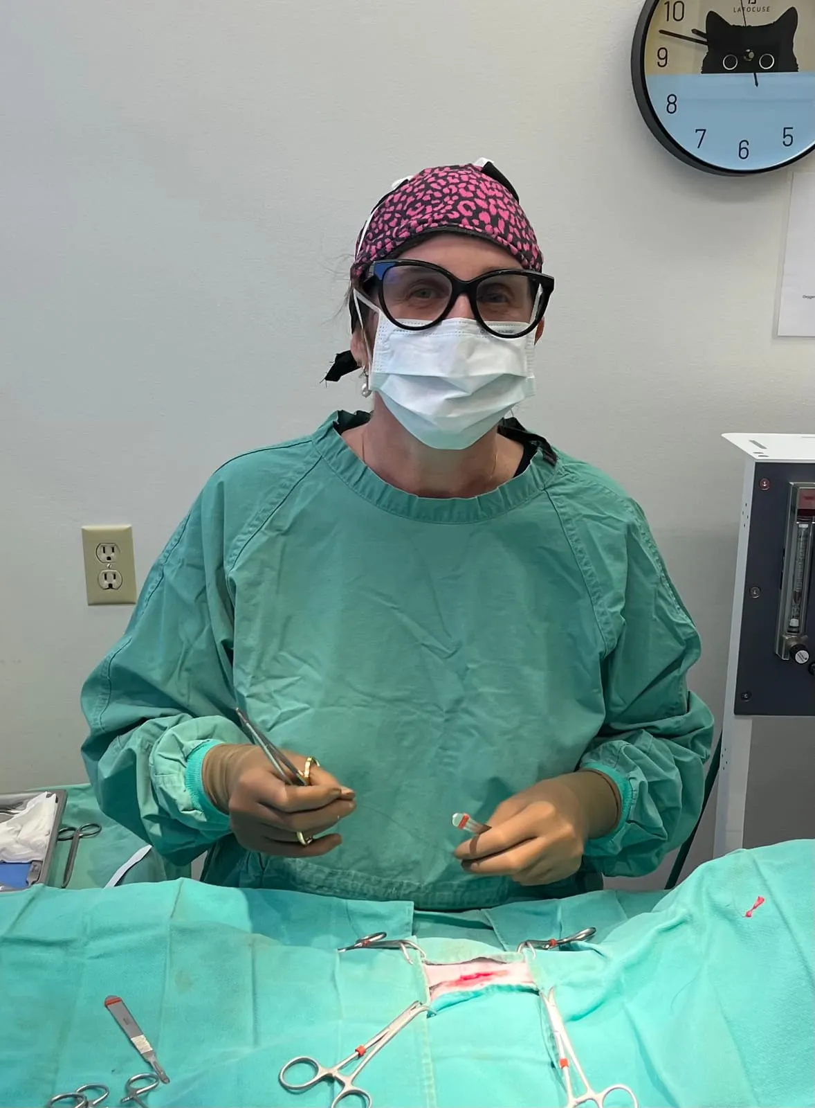 A surgeon in a cap, mask and gown preparing for surgery