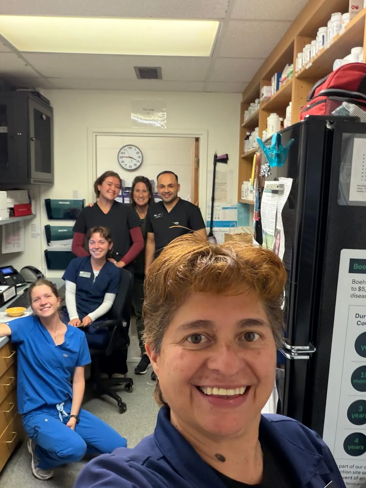 A team member taking a selfie with the rest of the team behind her