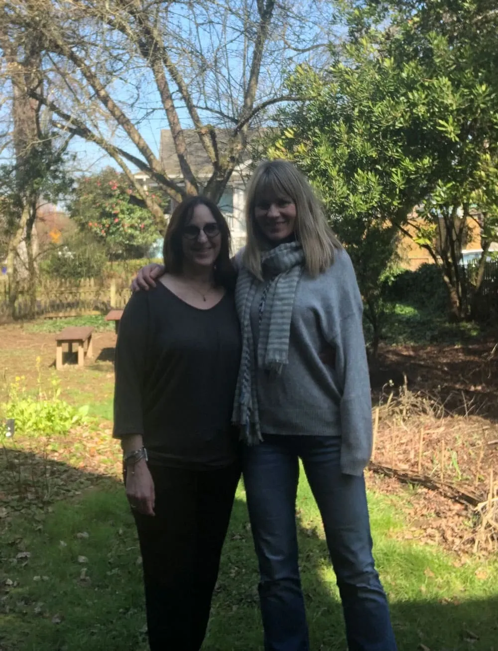 Two women standing together in a garden